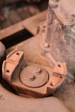 Paslı bir endüstriyel metali, ağır makinelerin vidalarıyla birleştirin. Yıpranmış demir mekanik bileşeni açık havada.