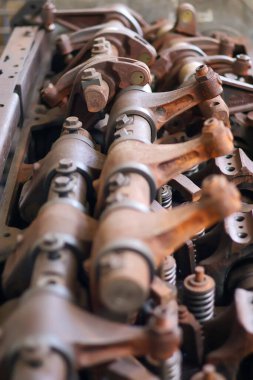 Mekanik bir atölyede rockçı kolları ve yayları olan paslı vintage motor valf treninin yakın çekimi.