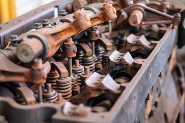 Mekanik bir atölyede rockçı kolları ve yayları olan paslı vintage motor valf treninin yakın çekimi.