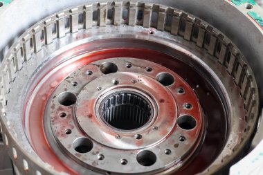 Bir endüstriyel atölyedeki profesyonel mekanik montaj süreci sırasında kırmızı yağlı yüksek hassasiyetli bir metal gezegen teçhizat taşıyıcısını kapatıyoruz..