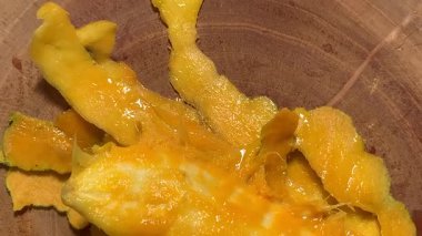 Tahtadaki taze soyulmuş mango etinin 4K görüntüsü sulu dokuyu ve doğal parıltıyı gösteriyor. Yakın çekim sıcak, tropikal ve organik bir hava yaratır. Yemek, tazelik, doğa konsepti için mükemmel.