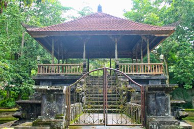 Endonezya 'nın Bali kentindeki verimli tropikal orman ve taş oymalarıyla çevrili Pura Tirta Empul tapınağında geleneksel pavyon.