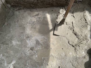 Çapayla harmanlanmış ıslak çimento, üst manzara. Kabataslak doku ve doğal ışık çok çalışmayı ve ilerlemeyi işaret ediyor. İnşaat, yenileme, inşaat, işgücü, sanayi ve diğer konular için ideal.