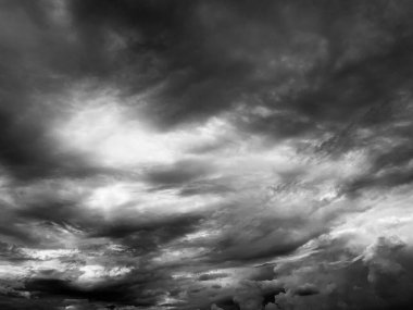 Siyah ve beyaz tonlarda dramatik fırtına bulutlarının geniş açı görüntüsü. Güçlü kontrast ve ağır doku yoğun ve duygusal bir ruh hali yaratır, hava konseptleri, iklim temaları ve karanlık soyut arka planlar için mükemmeldir.