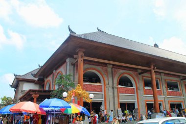 Geleneksel mimarisi olan Ubud Market Bali Endonezya binası, geniş açılı geniş açıyla çekildi. Keskin odak, meşgul satıcıları ve ziyaretçileri gösteriyor. Enerjik kültürel ruh hali. 11 Eylül 2024-Endonezya.