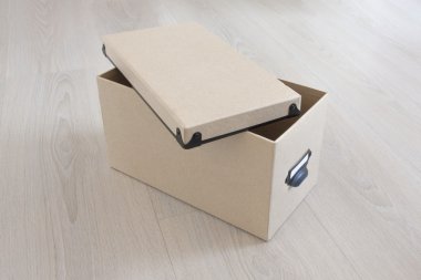 Ahşap arka plan üzerinde kapaklı karton kutu.