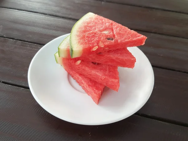 Fresh slices of watermelon on a plate on the wooden table — Stock Photo, Image