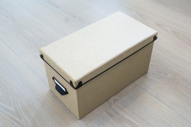Ahşap arka plan üzerinde kapaklı karton kutu.