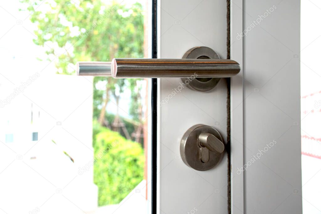 The aluminum handle of the window closes. Sliding door lock with background