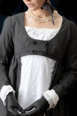 Beyaz çarşaf giyen bir naip kadın ve Spencer bir odada dikiliyorlar.