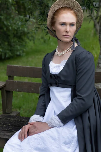 一位摄政妇人 身穿白色的麝香裙 挥金如土 头戴一顶帽子在花园里 — 图库照片