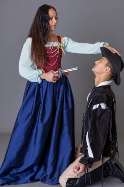 Gri bir stüdyoya karşı silahları olan bir korsan çift.