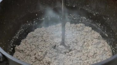 Kıymayı karıştırmak ya da odun ateşinin üzerine demir bir su ısıtıcısı koymak..
