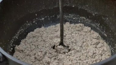 Kıymayı karıştırmak ya da odun ateşinin üzerine demir bir su ısıtıcısı koymak..