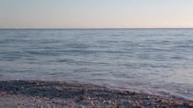 Güneşli bir günde kumlu sahilde dalgaların güzelliği.