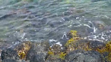 Okyanus dalgaları deniz kıyısındaki kayalarda kırılıyor..