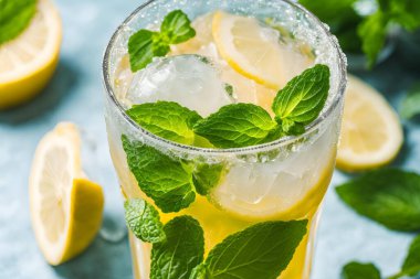 Soğuk limonata, taze nane yaprakları, limon dilimleri ve buz küpleri. Bardakta servis edilen ferahlatıcı yaz içeceği..