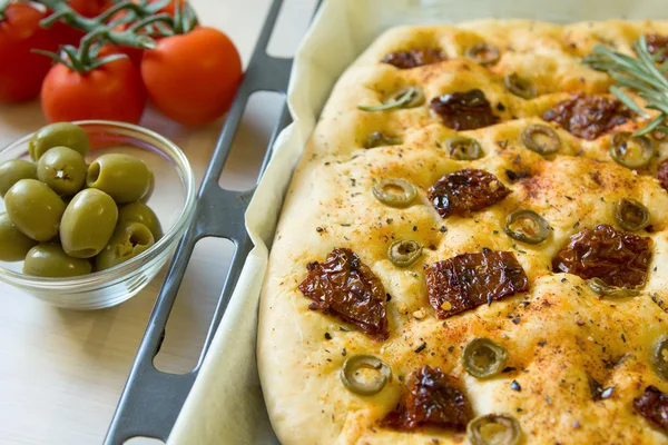Świeżo upieczony chleb tradycyjny włoski focaccia z oliwkami i suszonymi pomidorami — Zdjęcie stockowe