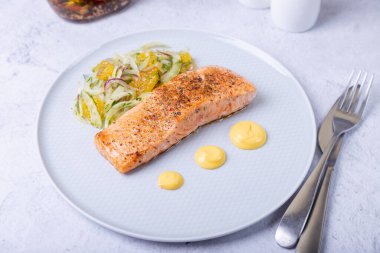 Rezeneli kızarmış somon ve Hollandez soslu portakal salatası. Fransız yemeği. Yakın plan..