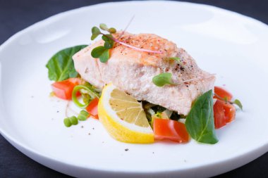 Sebzeli, limonlu ve mikroyeşillikli alabalık (somon) konfit metoduyla pişirilir. Geleneksel Fransız yemeği. Adım adım. Yakın plan..