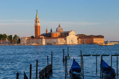Gün batımında San Giorgio Maggiore Bazilikası. Ön planda, gondollar San Marco Meydanı 'nda demirli..
