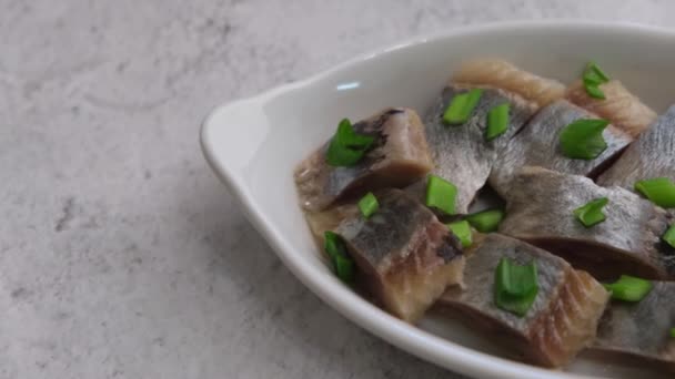 Pezzi Filetto Aringa Sono Cosparse Cipolle Verdi Piatto Bianco Pesce — Video Stock