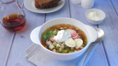 Kvass ve sosisli Okroshka. Geleneksel soğuk Rus çorbası. Kamera yakınlaştır, yakınlaştır.