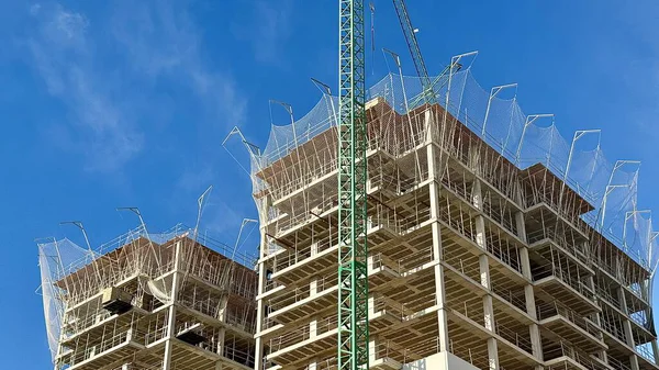 Gökyüzüne karşı Crane kulesi olan yüksek binalı bir bina. Yüksek kalite fotoğraf