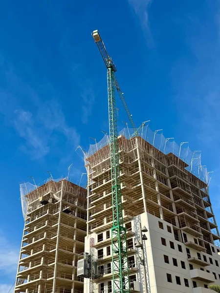 Gökyüzüne karşı Crane kulesi olan yüksek binalı bir bina. Yüksek kalite fotoğraf