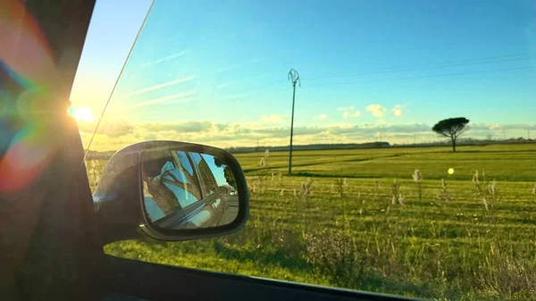 Otomobil Kenarı Aynası, Sunset 'teki Yeşil Kır Manzarası Yolculuk Konsepti. Yüksek kalite fotoğraf