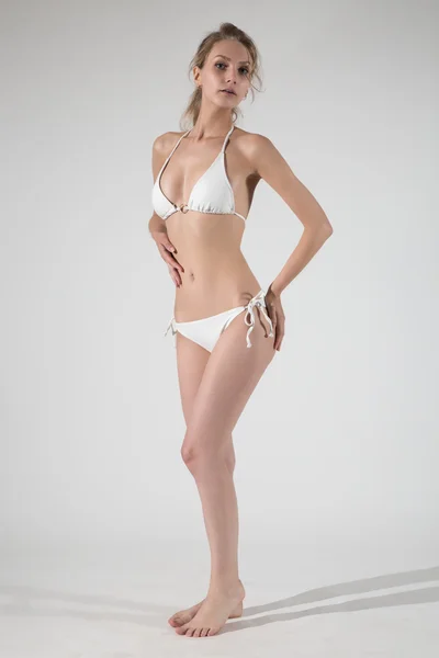 Mooie vrouw in witte lingerie camera kijken — Stockfoto