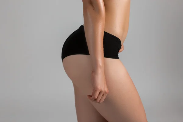 Belas ancas de mulher desportiva. Isolado no fundo cinzento — Fotografia de Stock