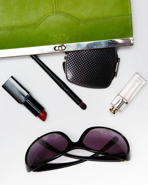 Top view accessories for woman. Stylish sunglasses, green bag , lipstick , perfume , fashion   flat lay on white