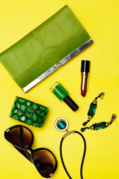 Vista dall'alto di accessori moda femminile. Borsa verde con rossetto collana guadagni braccialetto — Foto Stock