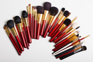 Düz yatıyordu. Beyaz arka planda makyaj fırçaları. üst görünüm