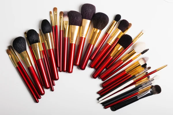 Düz yatıyordu. Beyaz arka planda makyaj fırçaları. üst görünüm