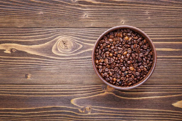Kahve çekirdekleri ve ahşap doku plaka arka plan çerçevesinde.