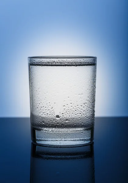 Холодный стакан чистой воды на синем фоне — стоковое фото