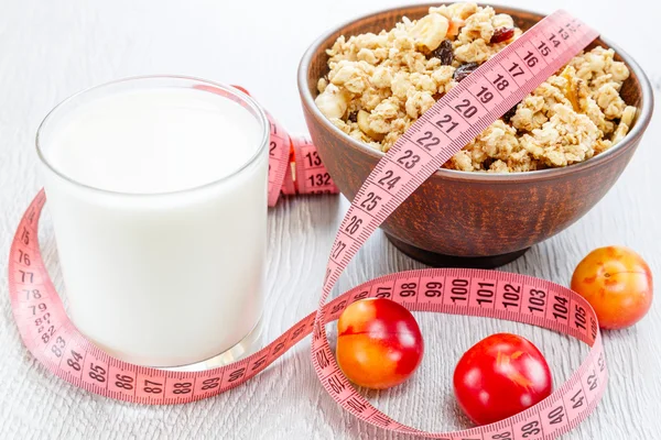 Muesli milk meter tape on wooden background