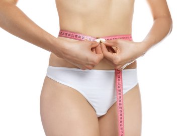 Elle bel, beyaz bir arka plan üzerinde yakınındaki güzel vücudu mükemmel şekli ölçme kırmızı metre tutan kadın