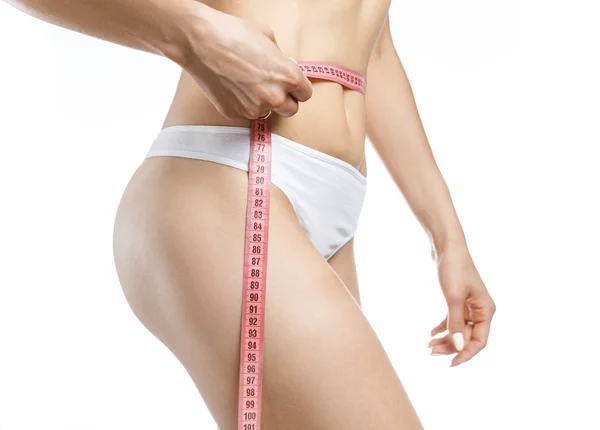 Elle bel, beyaz bir arka plan üzerinde yakınındaki güzel vücudu mükemmel şekli ölçme kırmızı metre tutan kadın
