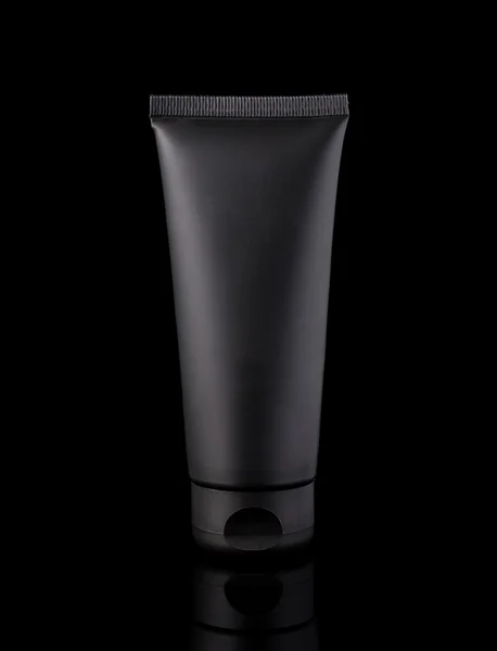 Tubo cosmético negro, fotografía de estudio de tubo de plástico negro para crema, aislado sobre fondo negro — Foto de Stock