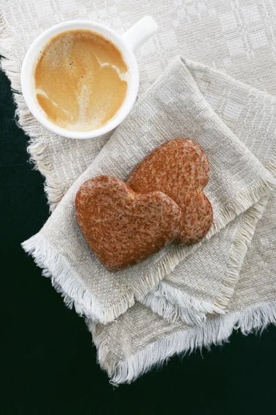 Cup of coffee with cakes in the shape of a heart on a napkin