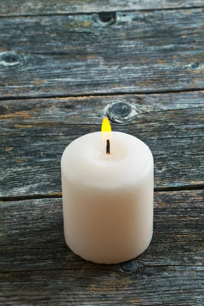 Белая горящая свеча на деревянном фоне — стоковое фото