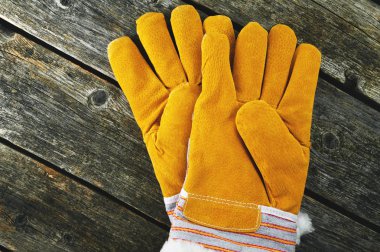 Ahşap bir zemin üzerine sarı iş eldivenleri