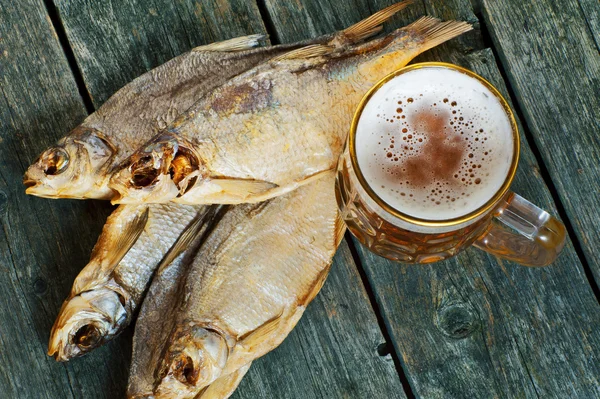 Горщик пива і сушена риба на дерев'яному фоні — стокове фото