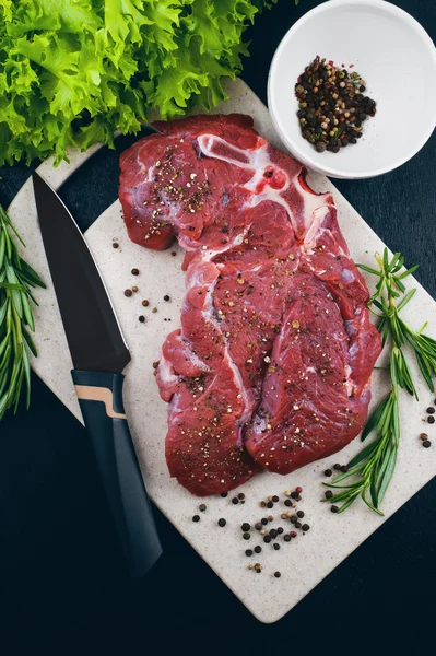 Beef, rosemary, pepper on a chopping board — Stock Photo, Image