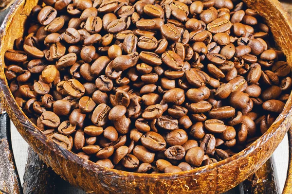 Granos de café en un plato de madera —  Fotos de Stock