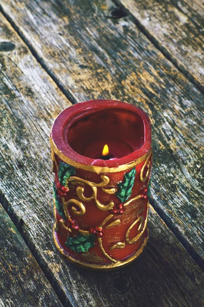 Горящая красная свеча на деревянном фоне — стоковое фото