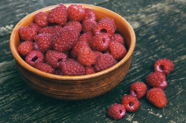 Raspberries in bowl on a wooden background — Stock Photo, Image